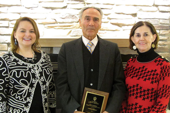 Professor Jamshid Mehran holds a Legacy Award plaque.